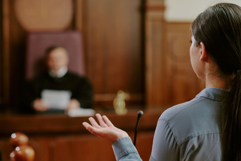 Woman giving evidence in a courtroom before a judge