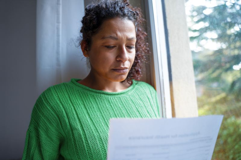 Woman reading a document with a concerned expression