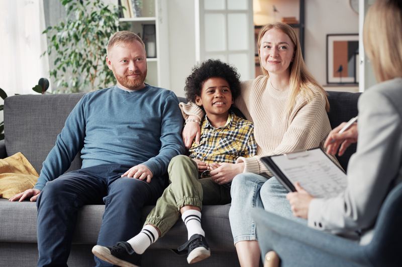 Family sitting on sofa during a home visit with a social worker